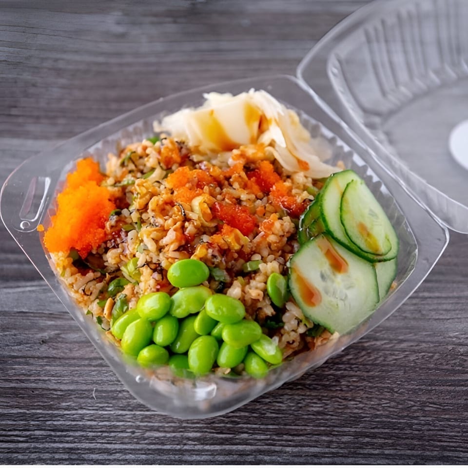 Poke bowl with rice, edamame, cucumber, and orange roe in a clear plastic container.